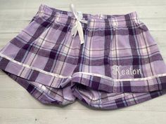 An adorable flannel sleep short that is comfortable, and easy to relax in. Add you name, monogram, single initial, or a title to make these perfect for any occasion. 100% Cotton, 2 ply waistband with satin drawstring. Stain piping at leg opening. Machine wash, cold. Tumble dry, low. No iron, no bleach. **Adult Sizing- Size chart with measurements in photos XXS- 00 XS- 0-2 S- 4-6 M- 8-10 Lrg- 12-14 XL- 16 2XL- 18 At checkout please provide the following in the personalization section: 1. Name or Plaid Shorts For Loungewear, Comfortable Cotton Bedtime Shorts, Plaid Pajama Shorts For Loungewear, Purple Cotton Pajama Shorts For Pajama Party, Cotton Purple Pajama Shorts For Pajama Party, Plaid Boxer Shorts, Sleep Shorts Womens, Plaid Boxers, Sleep Shorts