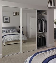 a bedroom with mirrored closet doors and white walls