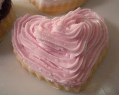 two heart shaped pastries with pink frosting on them