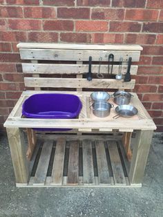 an outdoor kitchen made out of pallets and wooden pallets with pots and pans on it