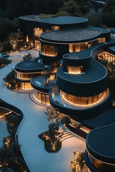 an aerial view of a building at night with lights on the windows and curved roof