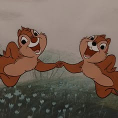 two chipmuns are holding hands in the air