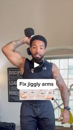 a man in black shirt and shorts standing next to a table with dumbbells on it