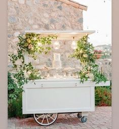 an old fashioned ice cream cart is decorated with greenery