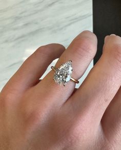 a woman's hand with a diamond ring on it