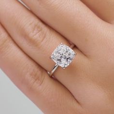 a woman's hand with a diamond ring on it