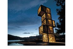 a tall building with lots of windows on it's side at night near the water