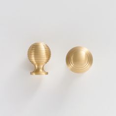 two brass knobs on a white background