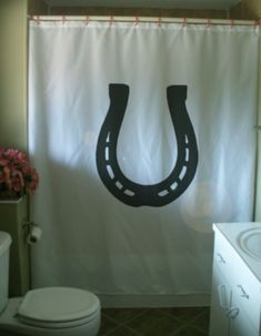 a bathroom with a shower curtain that has a black horseshoe on it