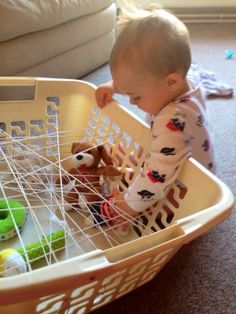 a baby playing with toys in a basket