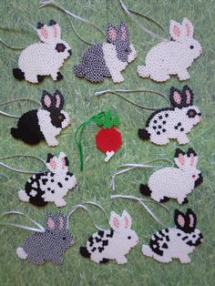 a bunch of small animal ornaments sitting on top of a grass covered ground with string