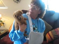 an older woman holding a small dog in her arms