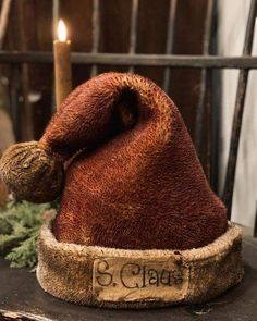 a brown hat sitting on top of a table next to a candle