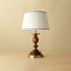 a wooden table lamp with a white lampshade sitting on it's side