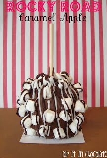 a cake with white and chocolate frosting on top sitting on a table next to a striped wall