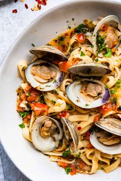 pasta with clams and tomatoes in a white bowl