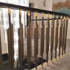 the railings are made of metal and have gold colored posts on each end, along with glass panels