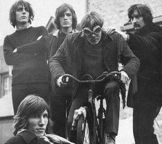 black and white photograph of men on bicycles with one man holding the handlebars