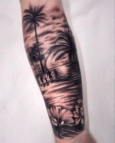 a man's arm with a palm tree and flowers on it