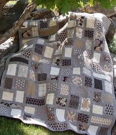 a quilted blanket sitting on top of a tree