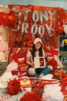 a woman sitting on top of a bed with balloons