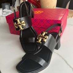 Crafted Of Rich Leather, Tory Burch's Eleanor Sandals Are Highlighted With Signature Double T Logo Hardware. This Square-Toe Pair Is Anchored By A Stacked Block Heel. Leather Upper Open Toe Ankle Buckle Strap Leather/Rubber Sole Imported Size Stacked Block Heel, 2" (55mm Luxury Slingback Sandals With Branded Heel Counter, Designer Black Slingback Sandals With Ankle Strap, Designer Slingback Sandals With Heel Strap, Luxury Black Open Toe Slingback Sandals, Designer Black Open Toe Slingback Sandals, Designer Slingback Sandals With Ankle Strap, Luxury Black Slingback Sandals With Heel Strap, Designer Slingback Sandals With Padded Heel, Elegant Tan Sandals With Leather Sole