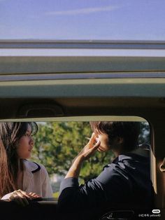 a man and woman sitting in the back of a car