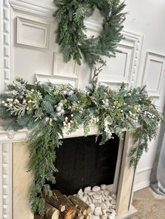 a fireplace decorated with greenery and pine cones