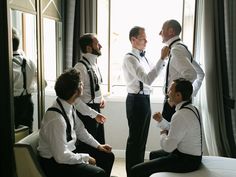 a group of men standing next to each other in front of a window