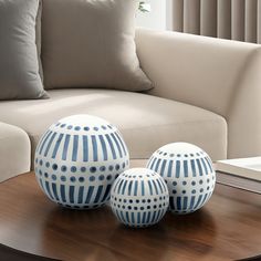 three blue and white vases sitting on top of a coffee table in front of a couch