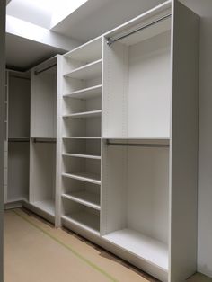 an empty walk in closet with white shelving and no one standing on the floor