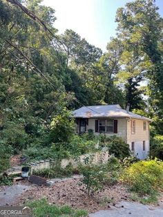 an abandoned house surrounded by trees in the woods