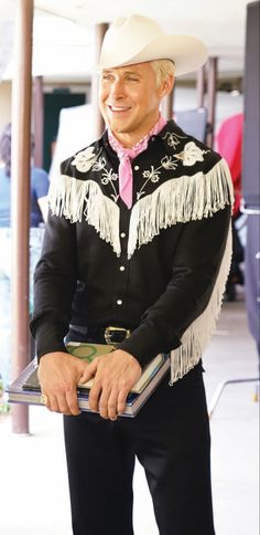 a man wearing a cowboy hat and holding a book