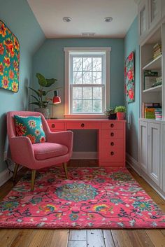 a pink chair sitting in front of a window next to a desk with a flowered rug