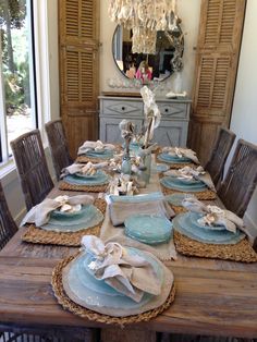 a dining room table set with blue plates and place settings for six people to eat