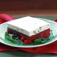 a piece of cake sitting on top of a green plate next to a red napkin