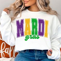 a woman wearing a white sweatshirt with the word mardi gras printed on it