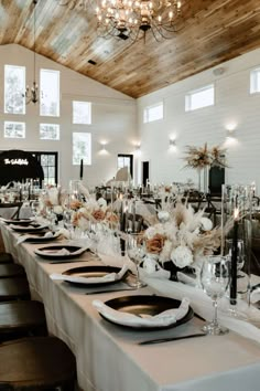 a long table is set up with place settings and centerpieces for an event