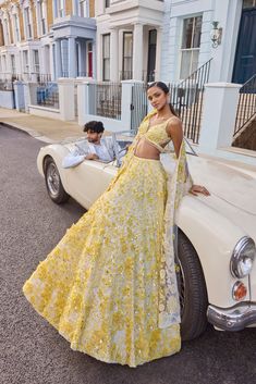 This lehenga set feature yellow three-dimensional highlighted with crystal, pearl and sequin on an ivory base. The waist of the blouse is scalloped and shows crystal drops. It is paired with four sided embroidered dupatta.From Seema Gujral's For the love of London collection. DELIVERY TIMEPlease allow 8-12 weeks for your outfit to arrive. FABRIC DETAILSNet Professional cleaning only. Yellow Indian Lehenga, Minimalist Mendhi, Bridal Garba Outfit, Mendhi Night Outfits, Modern Indian Clothes, Pastel Yellow Lehenga, Seema Gujral Lehenga, Strapless Lehenga, Yellow Indian Wear