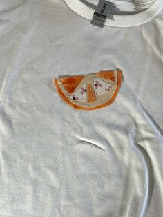 a white t - shirt with an orange slice cut in half