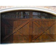 a large wooden garage door in front of a brick building