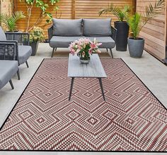 an outdoor living area with couches and tables