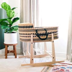 a basket sitting on top of a wooden stand next to a potted plant