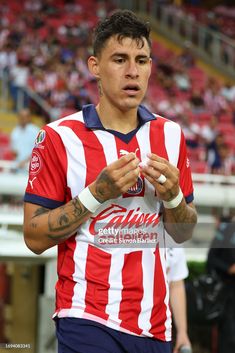 a soccer player holding his hands together in front of the crowd at a stadium stock photo