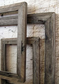 three wooden frames sitting on top of a white wall next to each other with one missing