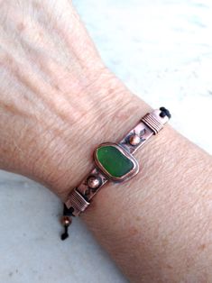 Adjustable bracelet with green sea glass, made of copper completely by hand. The top of the bracelet is a 60 X 7 mm (2.36 X 0.28 inch), textured copper strip with copper wire and soldered balls as decoration. The copper piece of the glass measures 19 X 13 mm (0.75 X 0.51 inches) and is soldered onto the copper strip. The crystal is bezel set. The maximum opening of the bracelet girth is 280 mm (11.02 inches) Please check your wrist measurements (photo 10) before ordering. The outline of the macr Bracelet Summer, Summer Bracelet, Sea Glass Bracelet, Summer Bracelets, Metal Ball, Unisex Bracelets, Glass Bracelet, Green Sea, Copper Bracelet