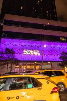 yellow taxi cabs are parked in front of a building with the word yotel on it