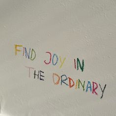 the word find joy in the ordinary written with colored crayons on white paper