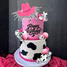 a birthday cake decorated with cow print and pink frosting