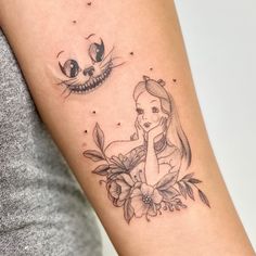 a woman with a tattoo on her arm has a cat and flower in front of her